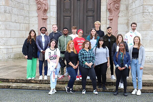 Eine Gruppe junger Menschen steht auf den Stufen des barocken Zwiefalter Münsters. 