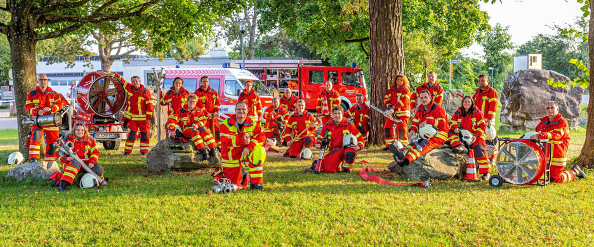 ZfP-Werkfeuerwehr Bad Schussenried Ein ganze Feuerwehrmannschaft in Uniform posiert auf einer Wiese