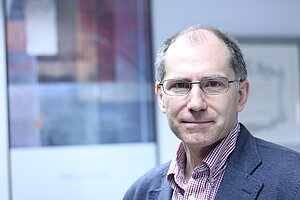 Portraitbild Professor Doktor Juan Waldes Stauber, ein Mann mittleren Alters mit Brille.