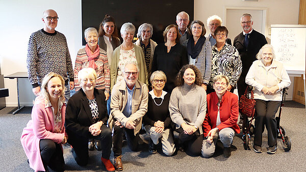 Eine Gruppe Menschen gemischten Alters posiert für die Kamera.