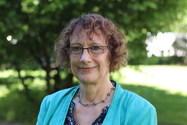 Portrait Bild von Prof. Dr. Renate Schepker. Eine Frau mittleren Alters mit lockigen Harren bis zum Kinn und einer Brille.