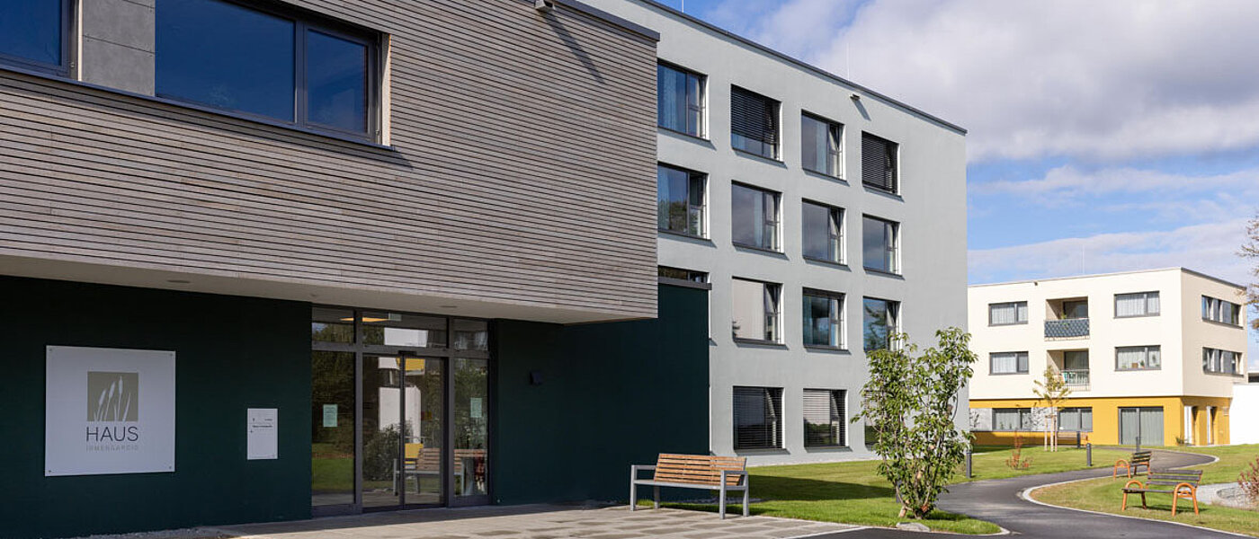 Ein modernes Gebäude mit holzverkleidetem Kubus unter blauem Himmel. 