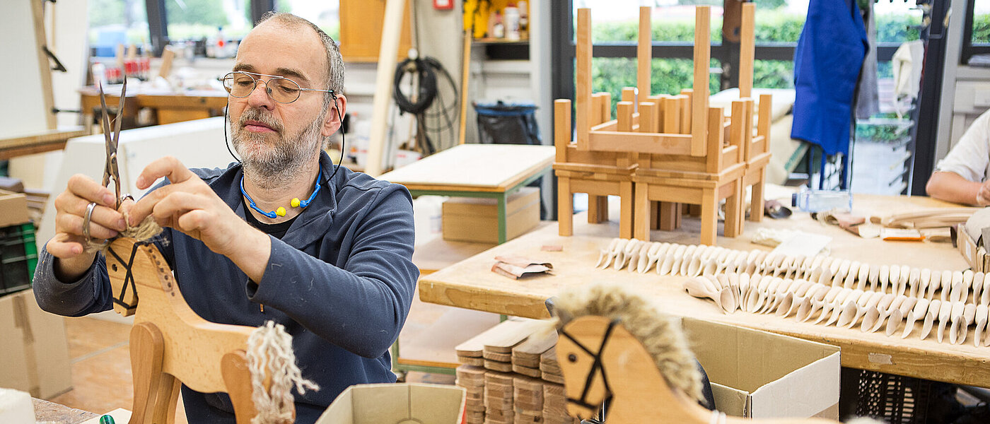 ein Mann in der Holzwerkstatt, der ein Holzpferd anfertigt