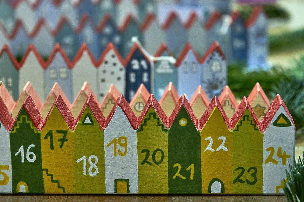 Weihnachtsdekoration mit kleinen bunten Häusern als Adventskalender.
