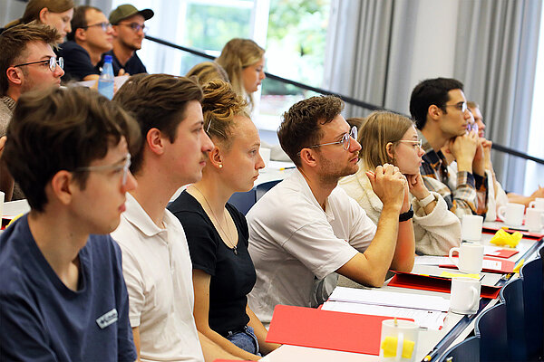 Junge Frauen und Männer sitzen im Hörsaal und folgen konzentriert der Vorlesung.