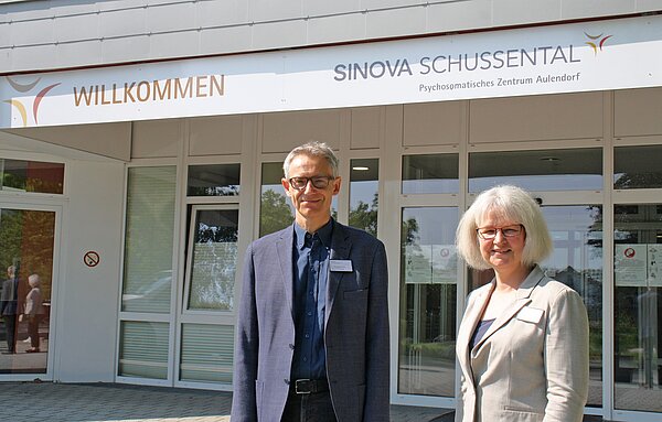 Eine Frau und ein Mann vor dem Haupteingang SINOVA Schussental Aulendorf