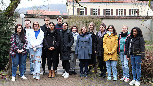 Eine Gruppe junger Menschen steht im Innenhof beisammen. 