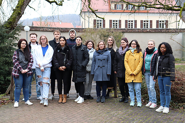 Eine Gruppe junger Menschen steht im Innenhof beisammen. 