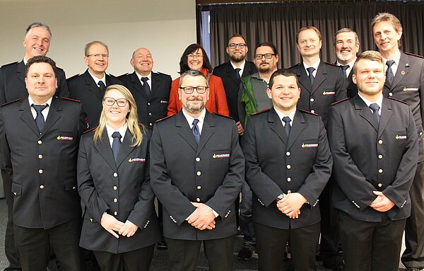 Die Werksfeuerwehr Zweifalten mit allen Mitarbeitenden. Vorne steht eine blonde Frau mit Brille. Hinten Mittig steht eine braunhaarige Frau, die eine rote Jacke trägt. Ansonsten sind nur Männer in Uniform der Feuerwehr zu sehen.