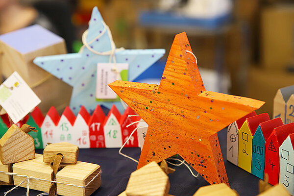Farbenfroh gestaltete Holzsterne zur Dekoration für die Weihnachtszeit.