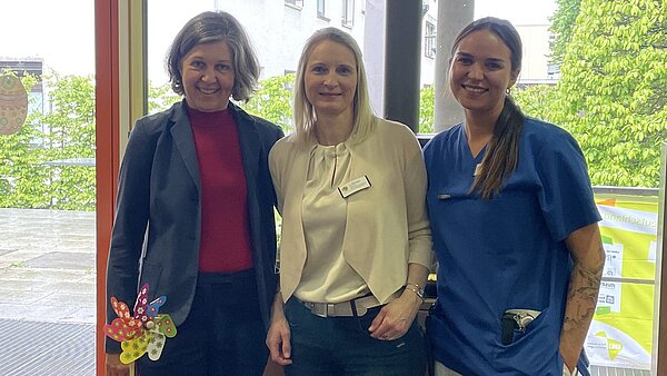 Drei Damen stehen hinter einem frisch bepflanzten Hochbeet und lächeln in die Kamera.