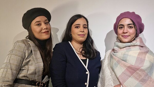 Drei junge Frauen stehen vor einer weißen Wand und schauen freundlich in die Kamera. Es handelt sich um die Pflegerinnen Meriem, Wala und Ramla, die vor einem Jahr von Tunesien nach Zwiefalten gekommen sind, um im ZfP Südwürttemberg zu arbeiten.