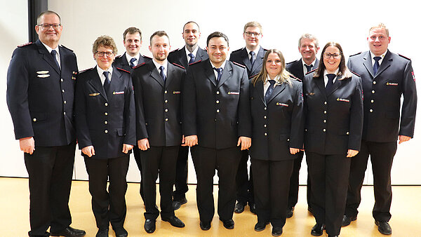 Ein Gruppenbild mit elf Personen in Feuerwehruniform. 