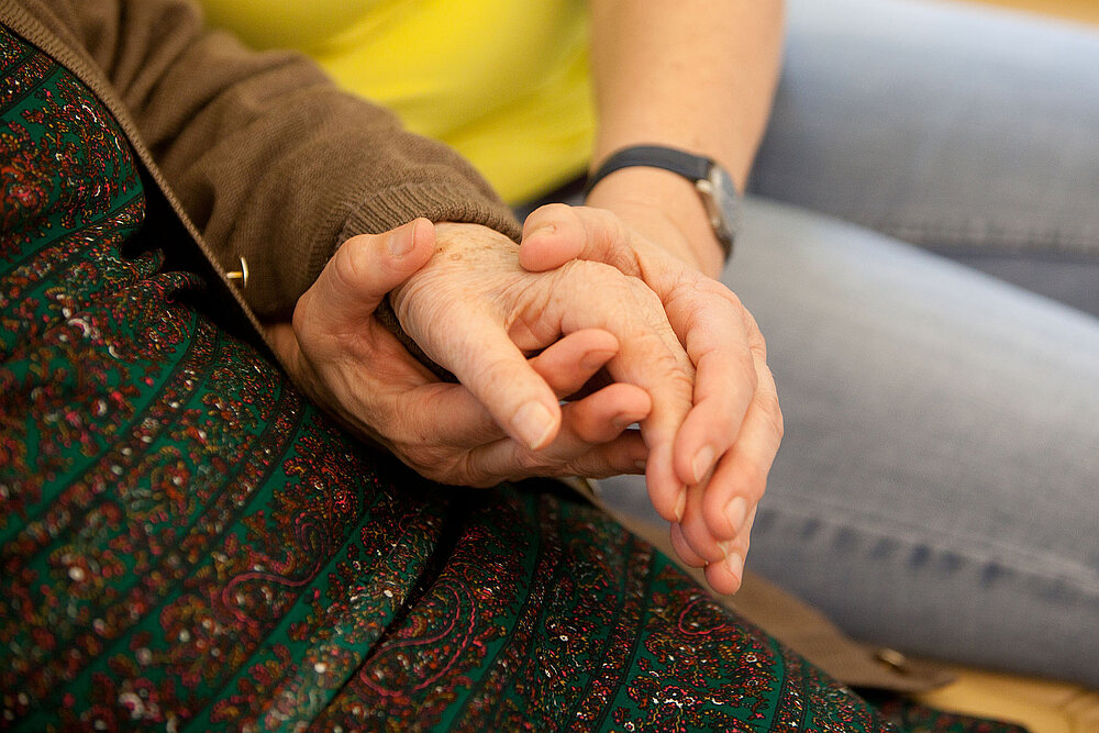 Veranstaltung des Netzwerk Demenz Eine Person hält die Hand eines anderen älteren Menschen